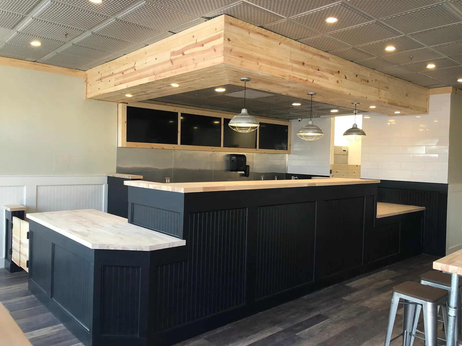 Completed SoBol Chino Hills service counter with finished casework, wood tops, menu screens, and pendant lights